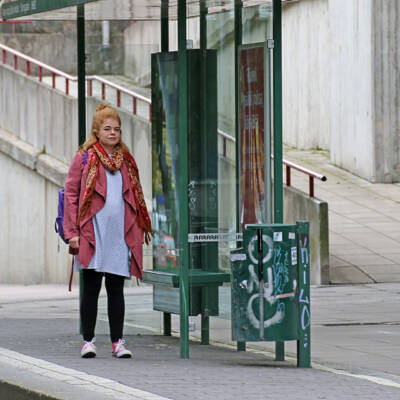 Nainen seisoo bussipysäkillä